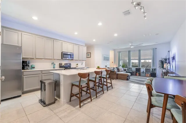 a kitchen with a dining table chairs and view of living room
