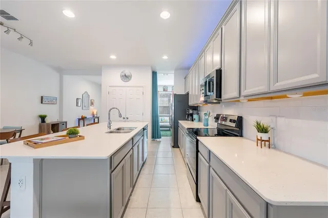 a kitchen with stainless steel appliances granite countertop a sink a stove and a refrigerator