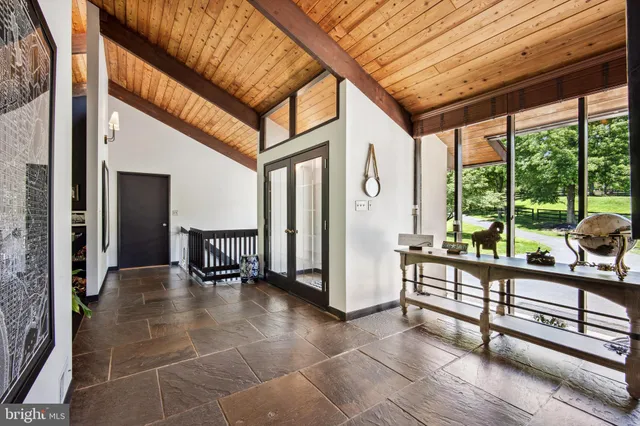 a view of a porch with chairs and couches with wooden floor and fence