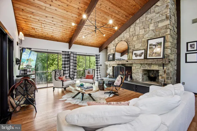 a living room with fireplace furniture and a large window