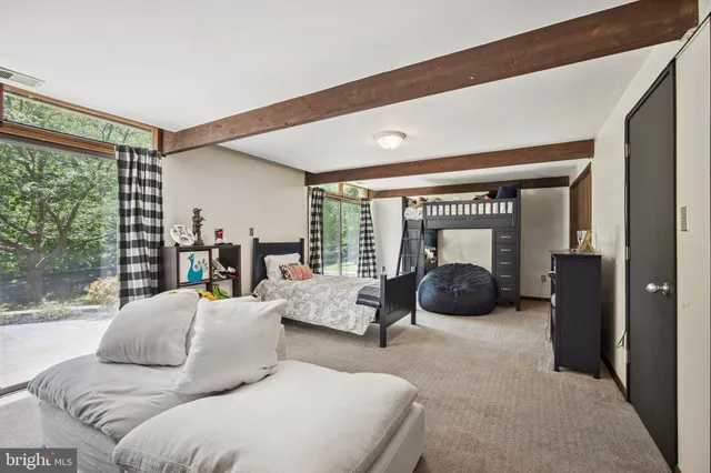 a bedroom with furniture and a large window