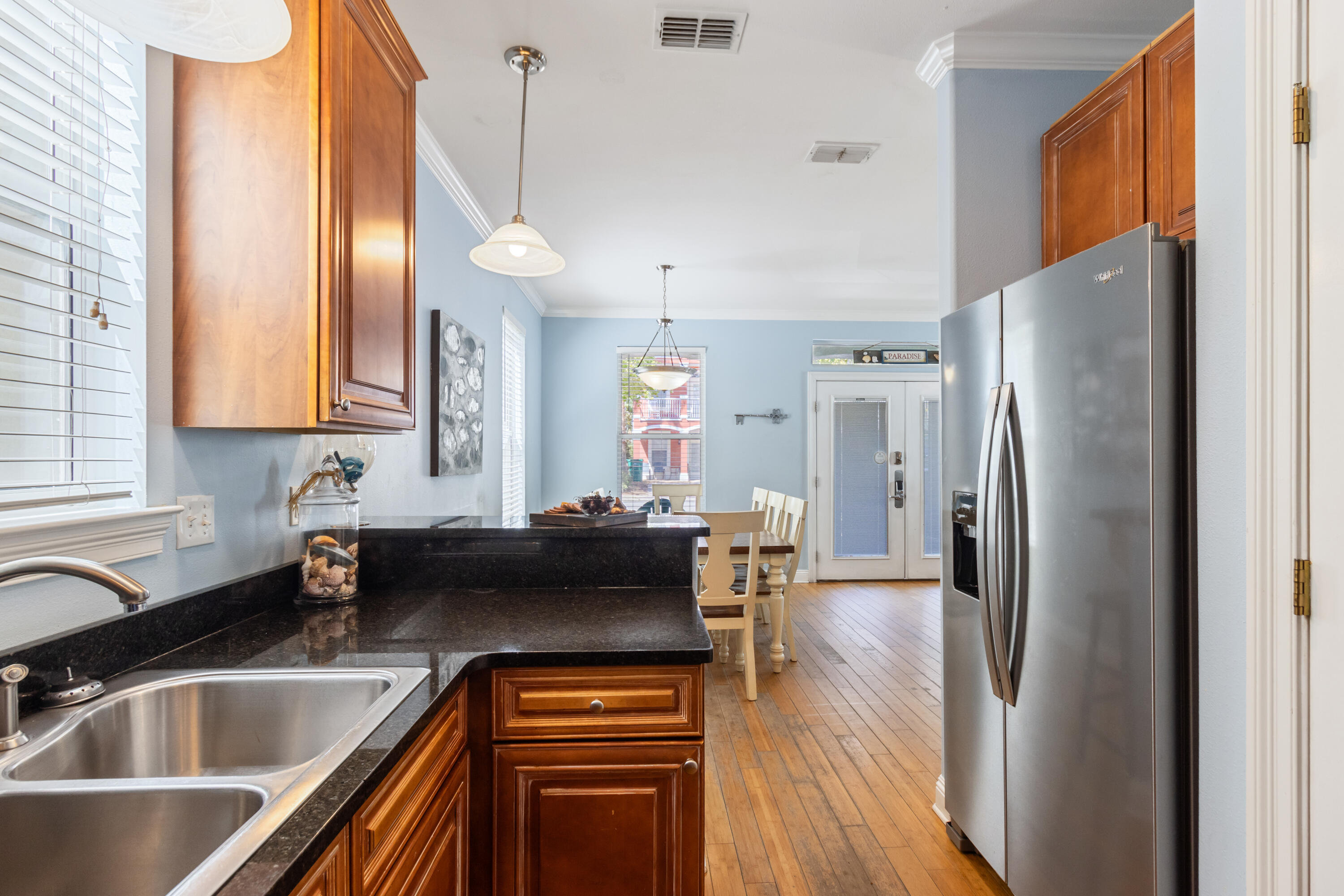 235 Kono Way Destin, FL 32541 - Photo 40 of 42 a kitchen with stainless steel appliances granite countertop a refrigerator a sink dishwasher a stove and a dining table with wooden floor