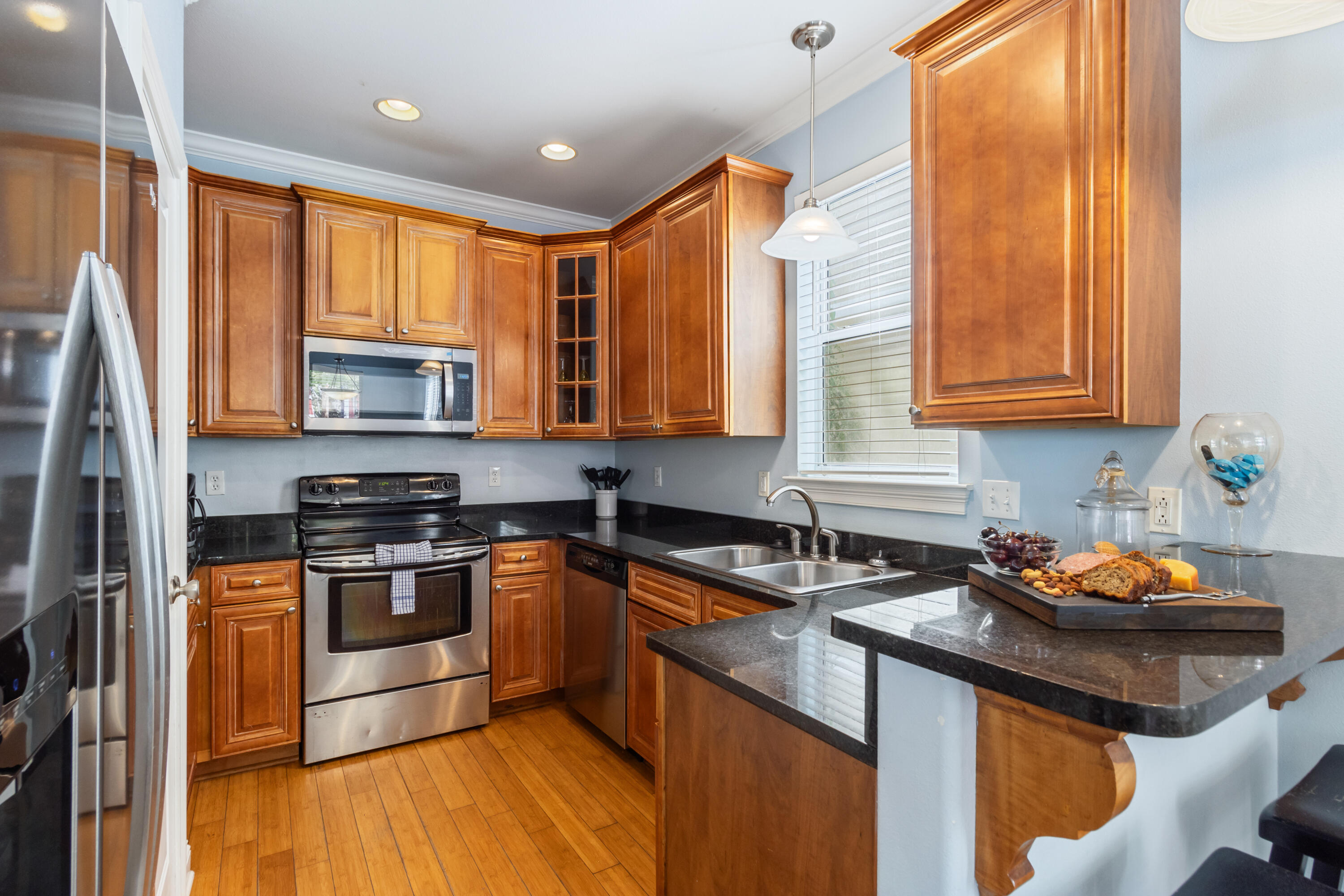 235 Kono Way Destin, FL 32541 - Photo 8 of 42 a kitchen with stainless steel appliances granite countertop a sink a stove a refrigerator cabinets and a window