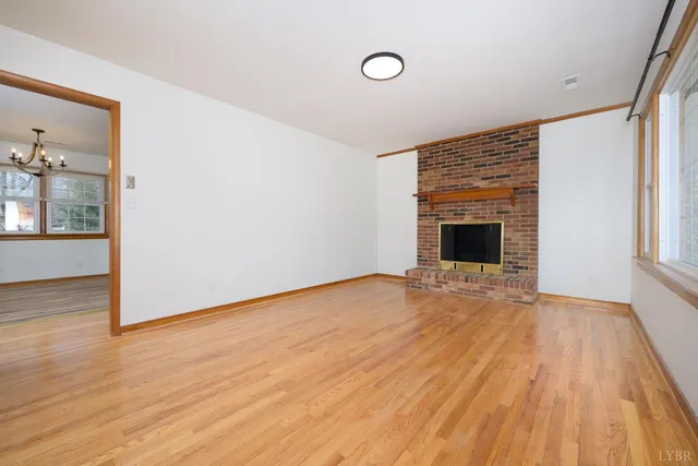 a view of empty room with wooden floor and fireplace
