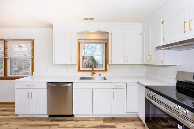 a kitchen with stainless steel appliances granite countertop a sink stove and cabinets
