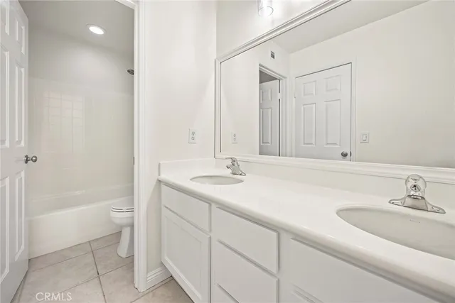 a bathroom with a sink a toilet and a large mirror