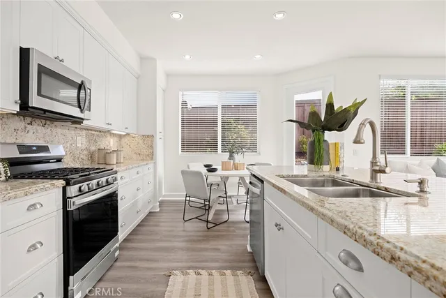 a kitchen with granite countertop a sink and a stove top oven