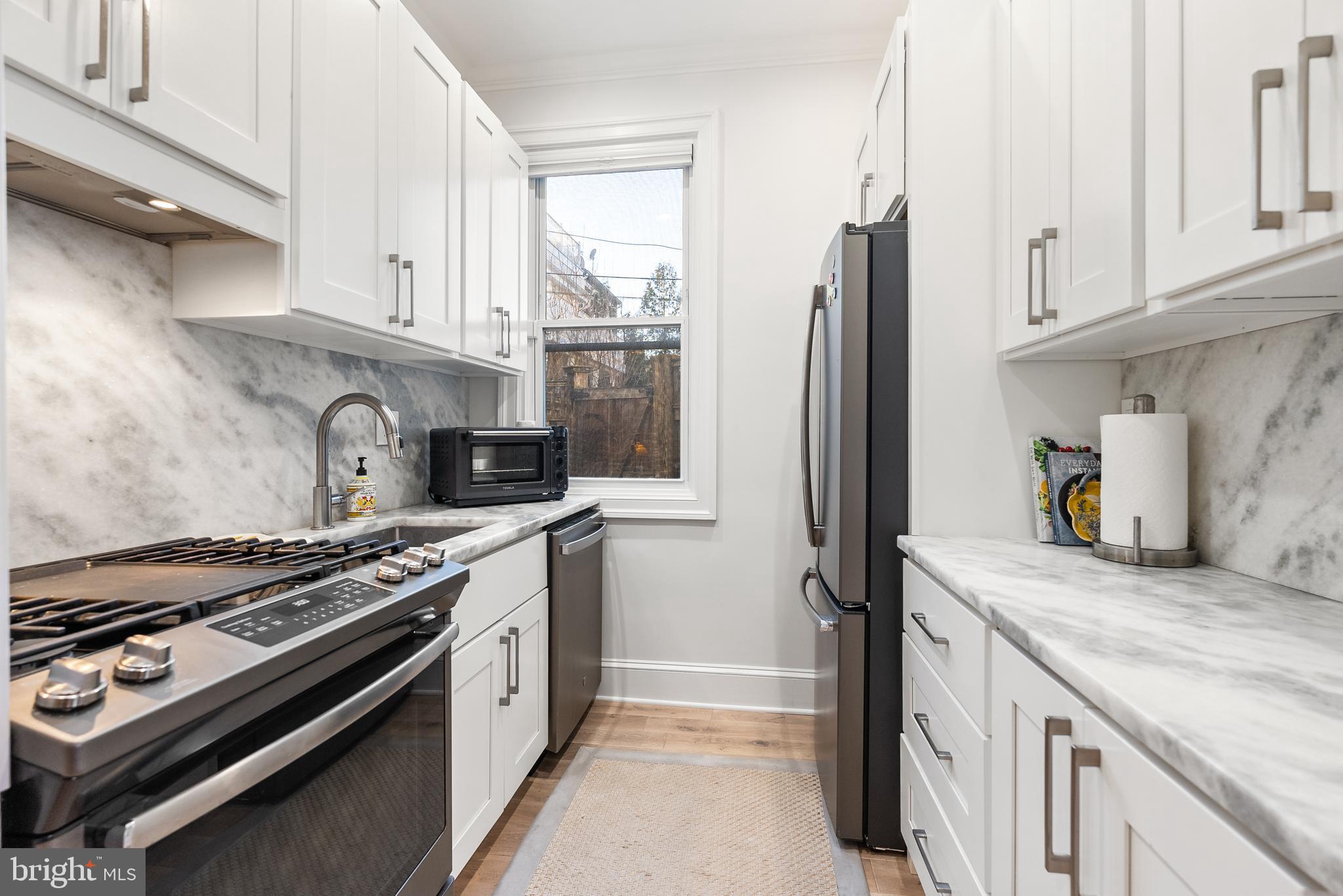 3237 N Street Northwest, Unit 16 Washington, DC 20007 - Photo 5 of 16 a kitchen with stainless steel appliances granite countertop a stove and a refrigerator