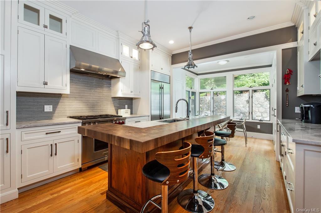 a kitchen with stainless steel appliances granite countertop a stove and a view of living room
