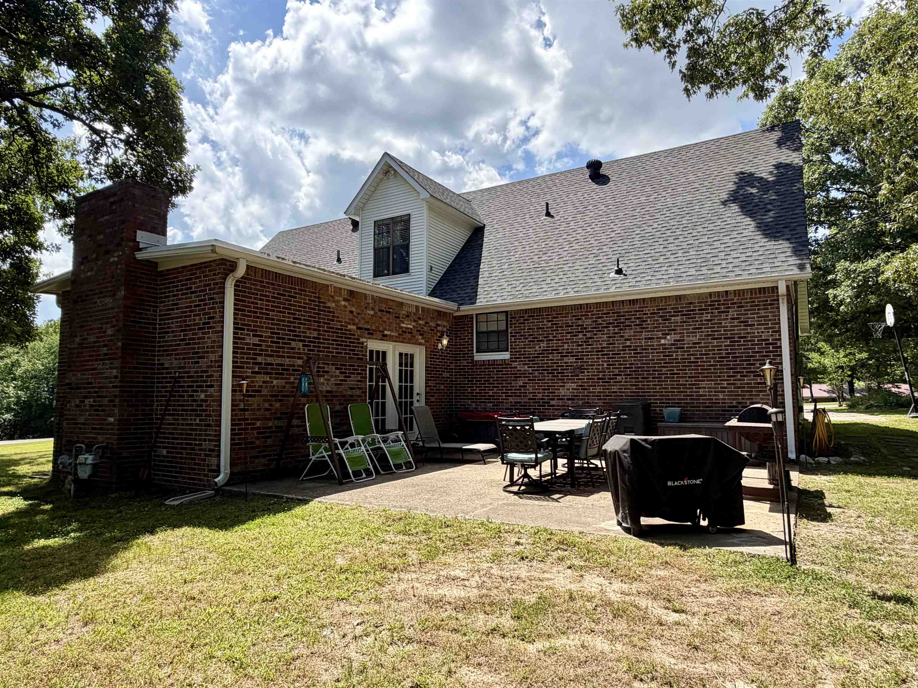 142 Treece Street Selmer, TN 38375 - Photo 26 of 36 Brick exterior featuring a gabled roofline, a prominent brick chimney, and white gutters