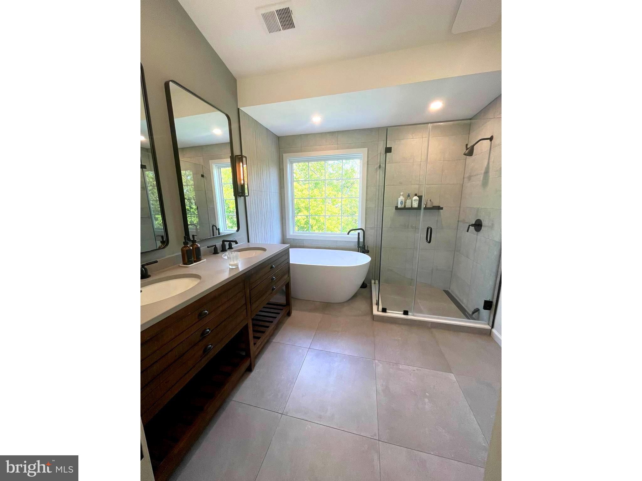 a spacious bathroom with a double vanity sink a toilet and a mirror