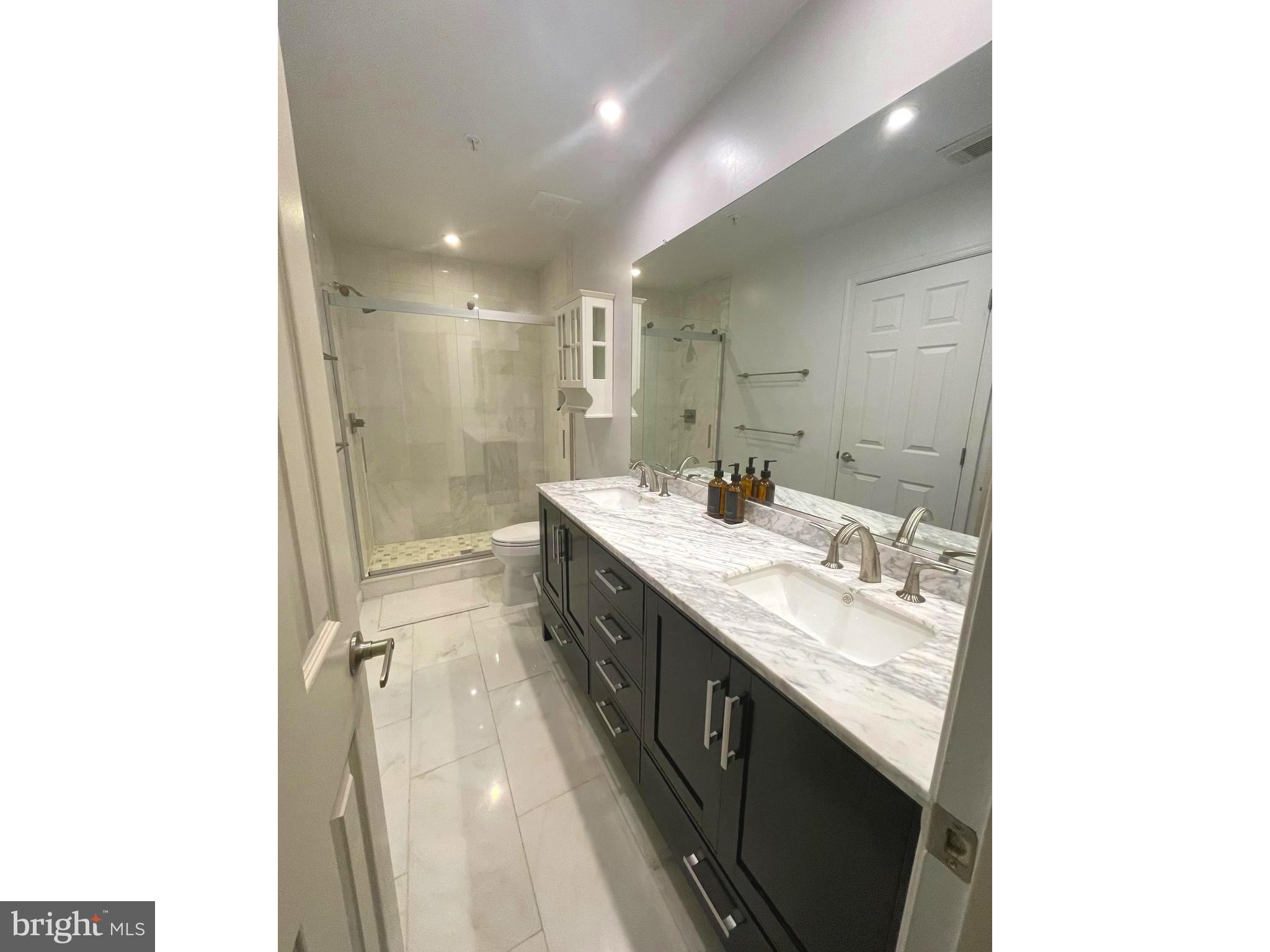 8406 Bells Ridge Terrace Potomac, MD 20854 - Photo 9 of 13 a bathroom with a double vanity sink and a mirror
