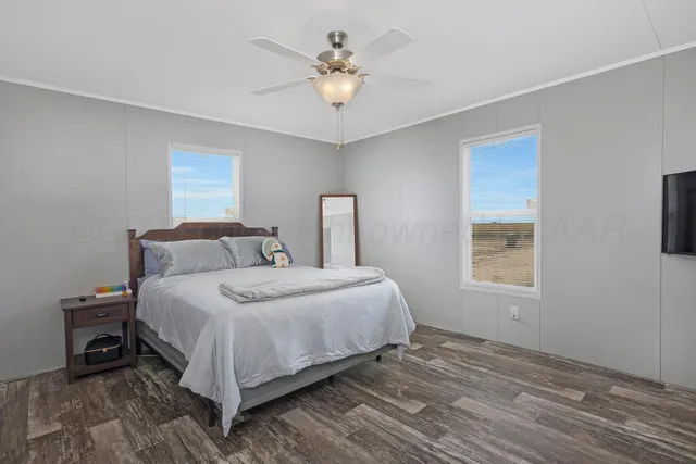 a bedroom with a bed a chandelier and a window