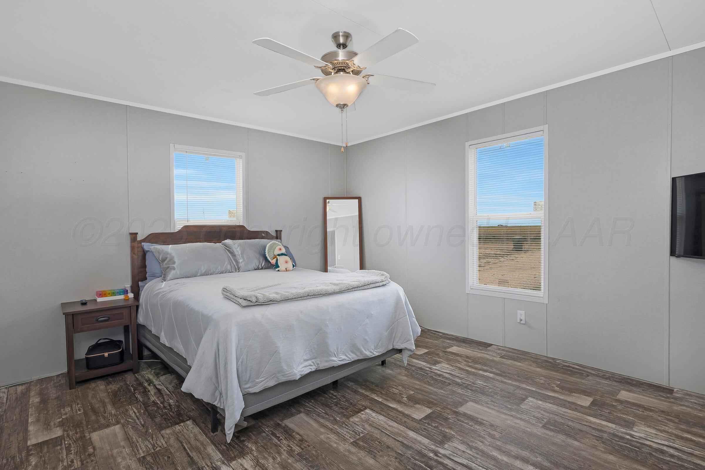 7979 Juett Attebury Road Amarillo, TX 79118 - Photo 11 of 22 a bedroom with a bed a chandelier and a window