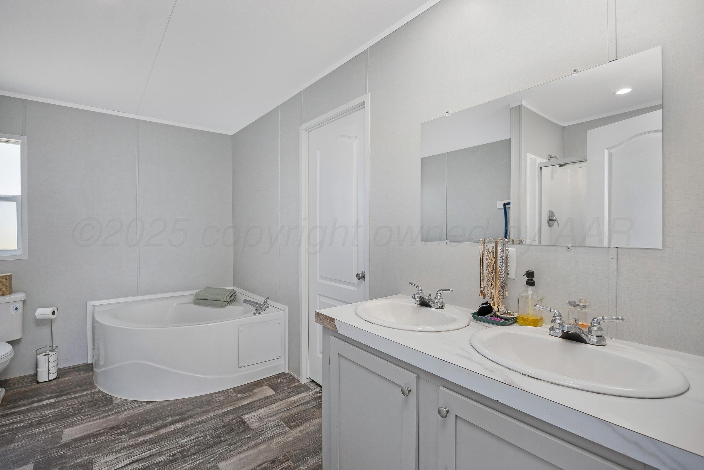 7979 Juett Attebury Road Amarillo, TX 79118 - Photo 13 of 22 a bathroom with a sink and a mirror