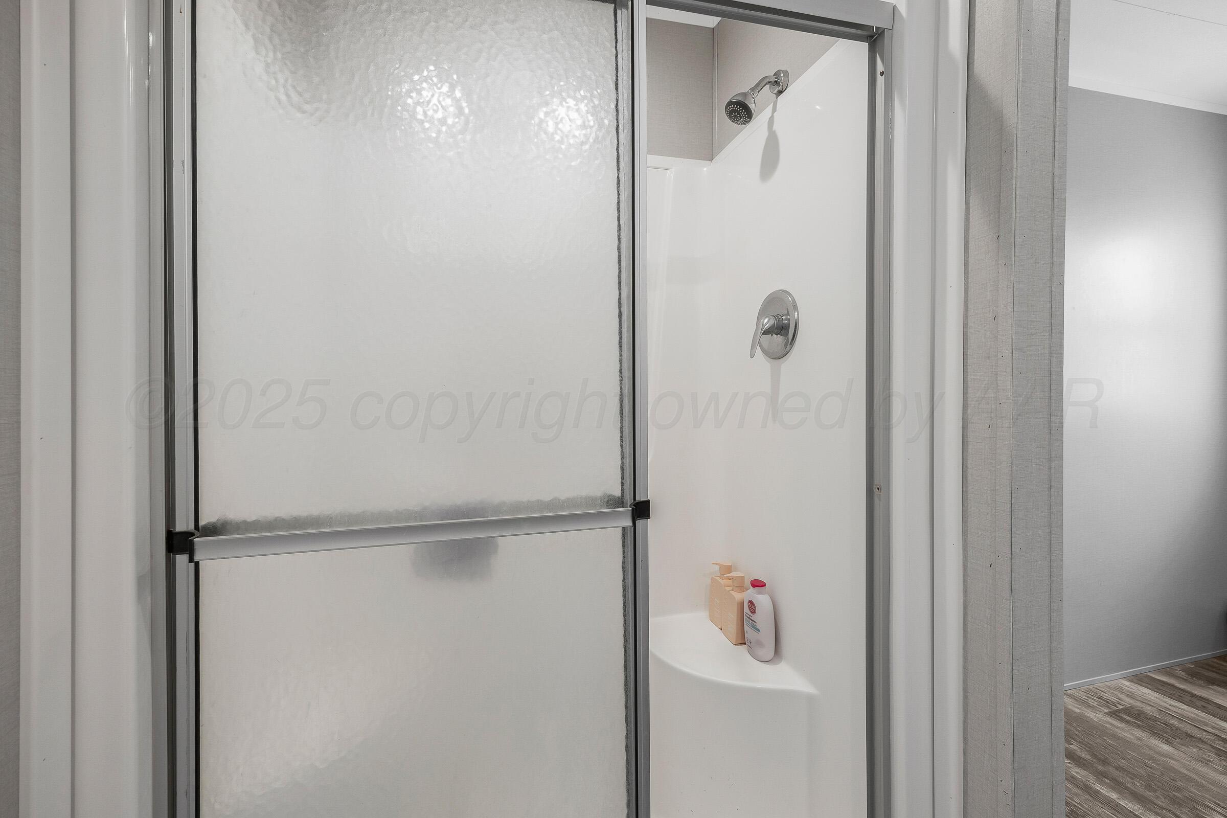 7979 Juett Attebury Road Amarillo, TX 79118 - Photo 14 of 22 a bathroom with a glass shower door