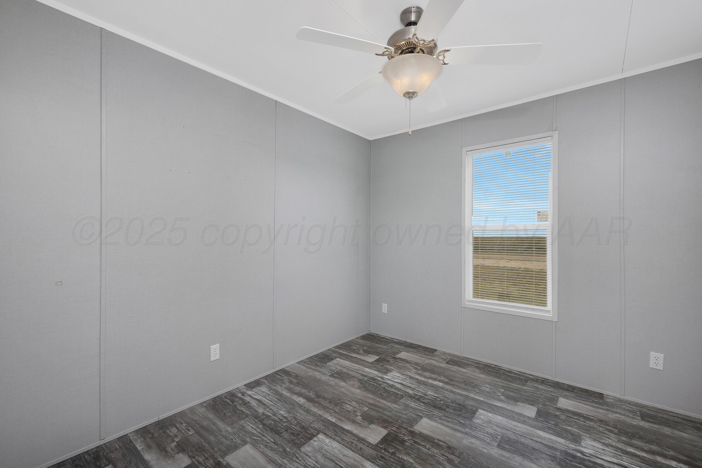 7979 Juett Attebury Road Amarillo, TX 79118 - Photo 15 of 22 an empty room with a window and a fan