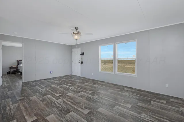 a view of a livingroom with a stove wooden floor and a window