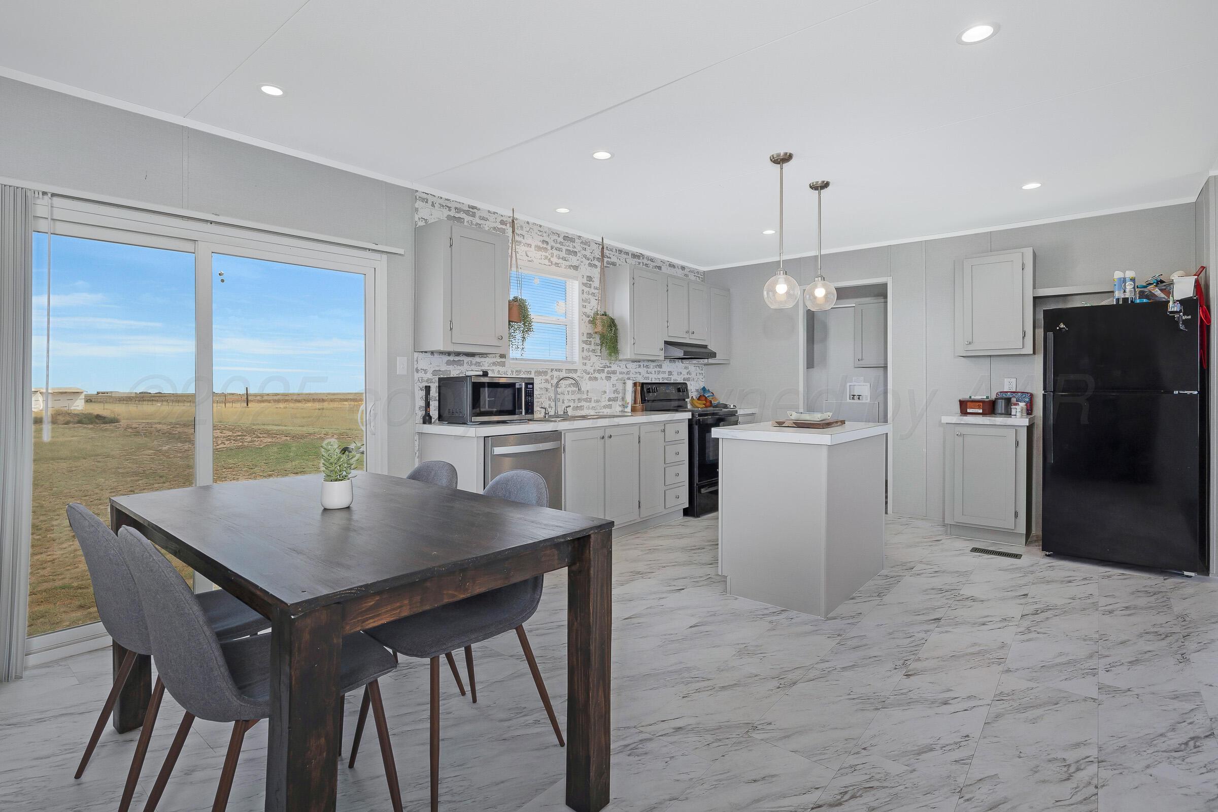 7979 Juett Attebury Road Amarillo, TX 79118 - Photo 5 of 22 a kitchen with a table chairs refrigerator and microwave