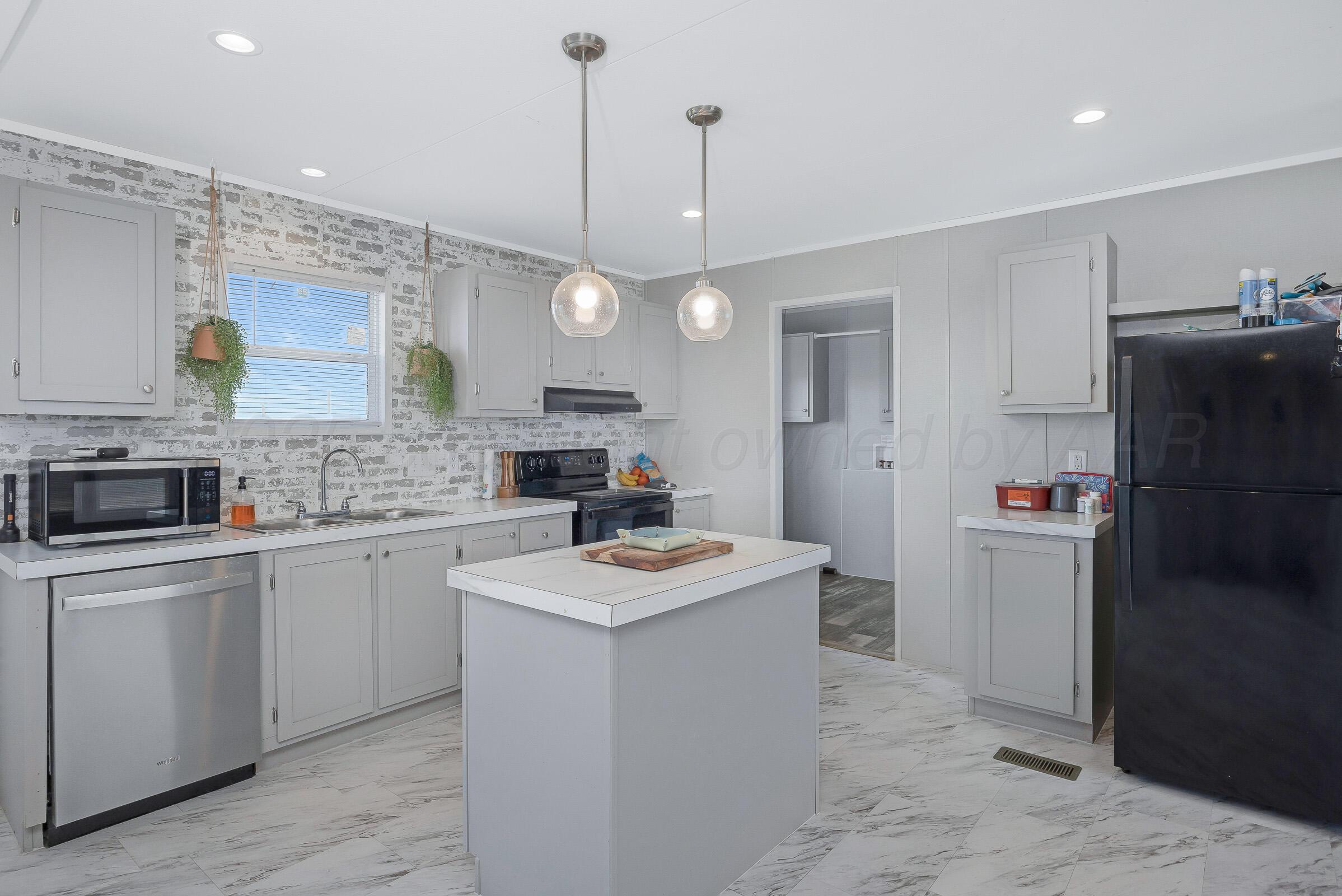 7979 Juett Attebury Road Amarillo, TX 79118 - Photo 6 of 22 a kitchen with a sink stove and refrigerator
