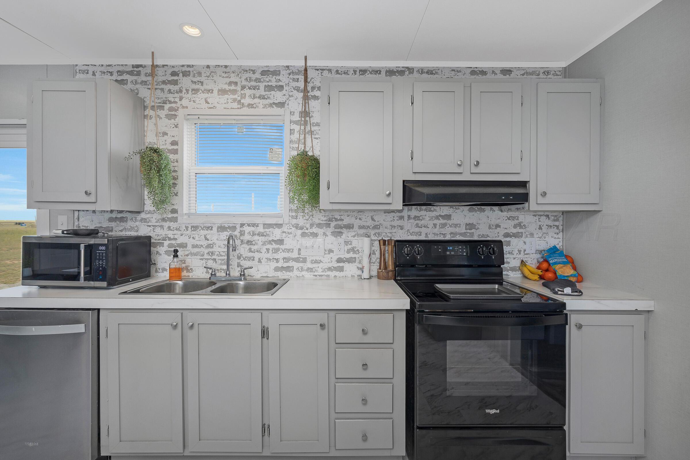 7979 Juett Attebury Road Amarillo, TX 79118 - Photo 7 of 22 a kitchen with white cabinets and appliances