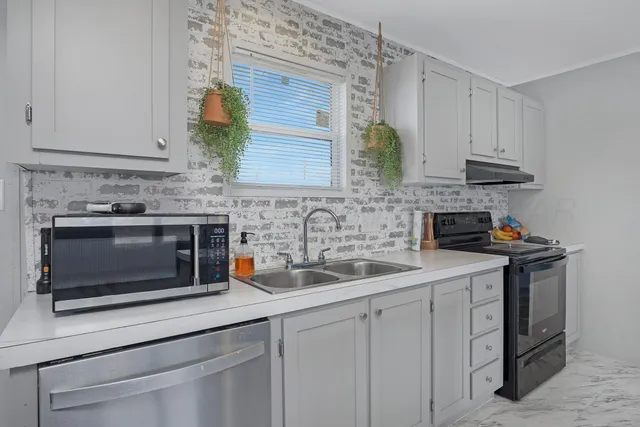 a kitchen with stainless steel appliances a stove sink and cabinets