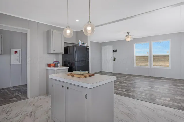 a kitchen with kitchen island white cabinets and refrigerator