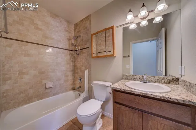 a bathroom with a granite countertop sink a toilet and bathtub