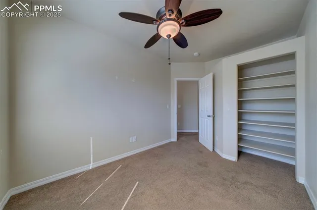 a view of an empty room with a ceiling fan