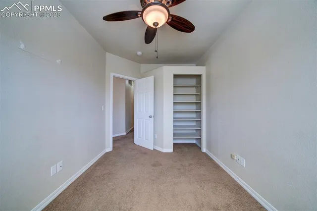 wooden floor in an empty room with a ceiling fan