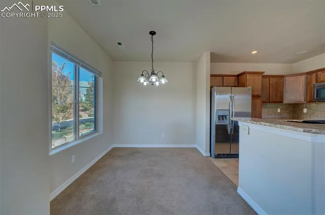 a view of a kitchen with a sink wooden cabinets and a window
