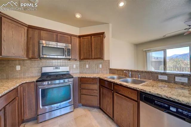 a kitchen with granite countertop a stove sink and microwave