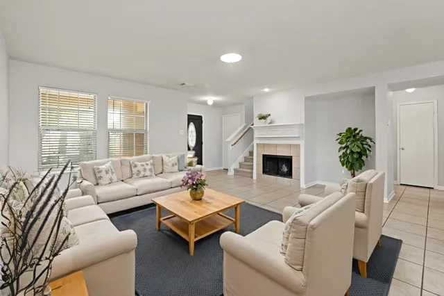 a living room with furniture a fireplace and a potted plant