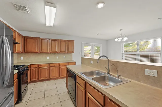a kitchen with granite countertop a sink stove and cabinets