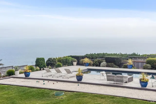 a view of swimming pool with lounge chair and lake view