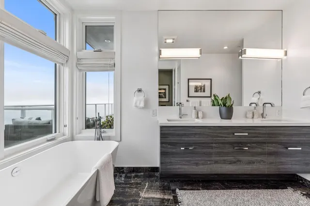 a bathroom with a sink a large mirror and a bathtub