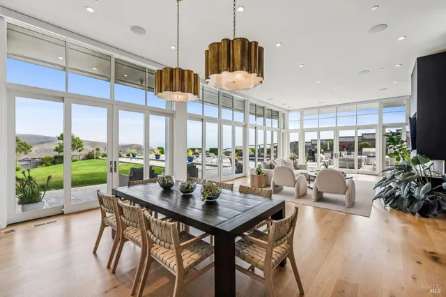 a view of a dining room and livingroom with furniture wooden floor a chandelier
