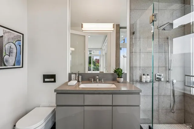 a bathroom with a sink a toilet and shower