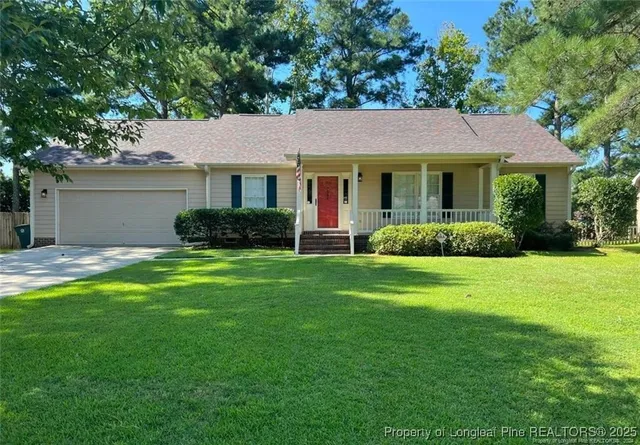 a front view of a house with a yard and green space