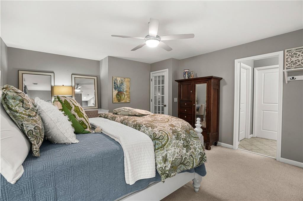 509 Crested Hawk Ridge Canton, GA 30114 - Photo 45 of 89 a spacious bedroom with a bed and ceiling fan