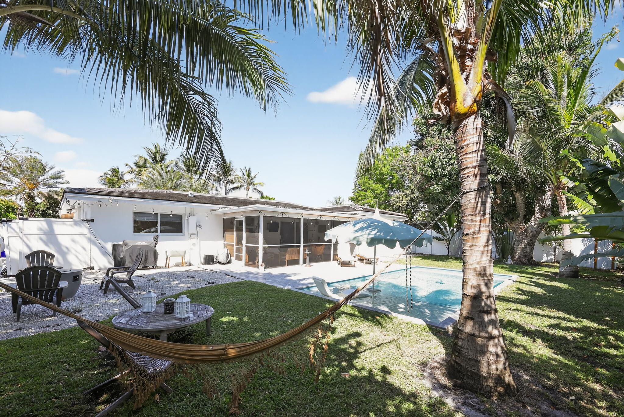 976 Southwest 11th Street Boca Raton, FL 33486 - Photo 6 of 29 a view of a backyard with table and chairs potted plants and palm tree