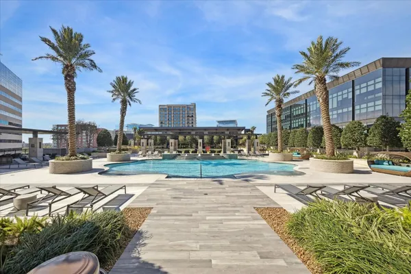 a row of palm trees and swimming pool in the backyard of a house