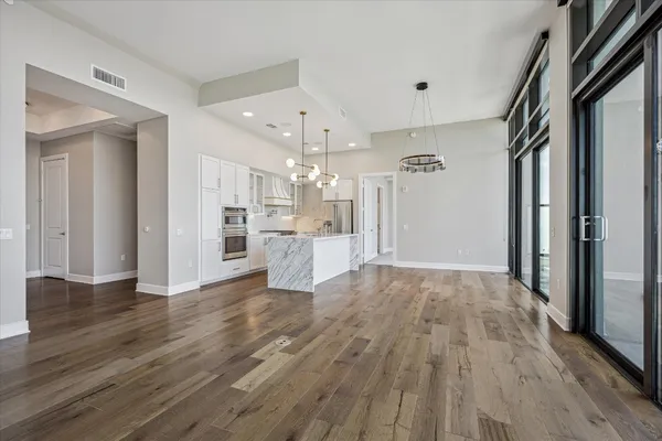 a view of a kitchen with wooden floor and a refrigerator