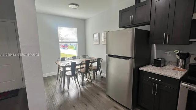 a kitchen with a table chairs refrigerator and microwave