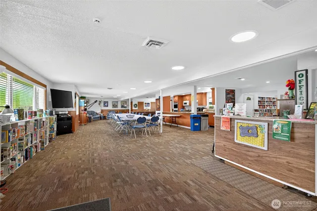 a large kitchen with granite countertop a large counter top stainless steel appliances a stove a sink dishwasher and cabinets with wooden floor