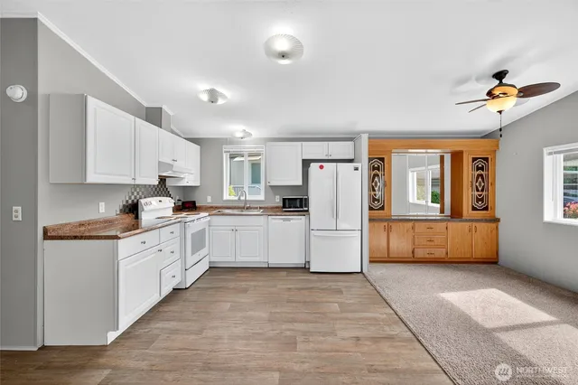 a kitchen with white cabinets and window