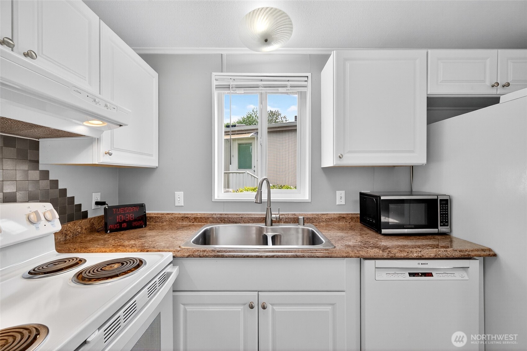 23825 15th Avenue Southeast, Unit 93 Bothell, WA 98021 - Photo 5 of 34 a kitchen with granite countertop a sink a stove and cabinets