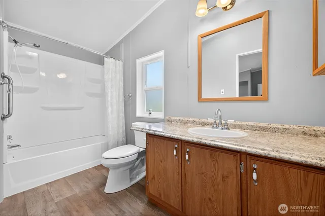 a bathroom with a granite countertop sink a toilet and a mirror