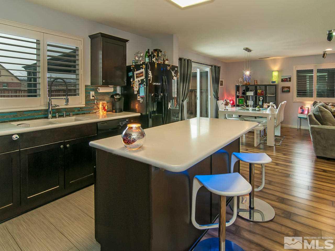 11535 Rivolli Court Reno, NV 89521 - Photo 6 of 22 a kitchen with stainless steel appliances kitchen island granite countertop a dining table chairs and granite counter tops