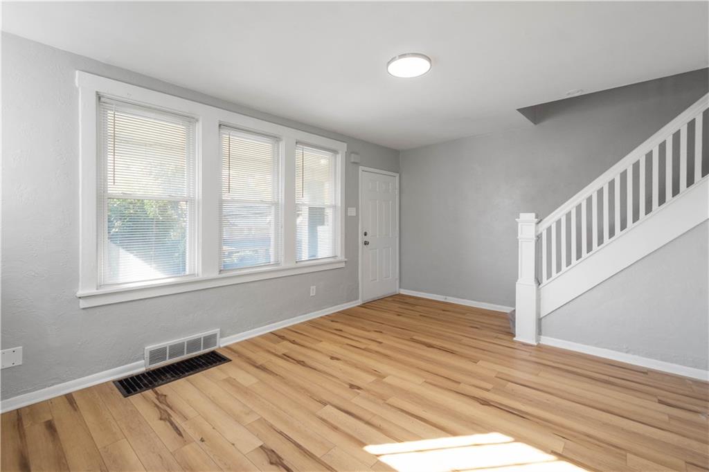 243 Castle Shannon Boulevard, Unit 243 Pittsburgh, PA 15228 - Photo 4 of 26 a view of an empty room with wooden floor and a window
